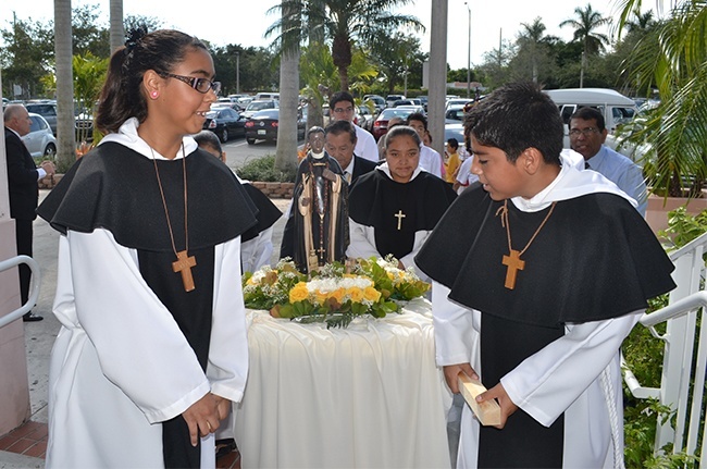 Carrying a small statue of St. Martin de Porres into the church, front, Mari Carmen Velasquez and Ruben Corona and back right Cecilia Mora.