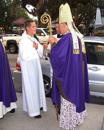 As they wait for the start of the Mass outside the Cathedral Basilica of St. Augustine, Archbishop Thomas Wenski explains the use of incense to altar server Fillipo Schiavo.