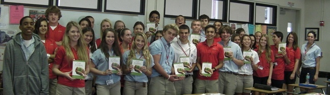 Theology teacher Nelson Araque and his students pose with their Care for Creation pamphlets.