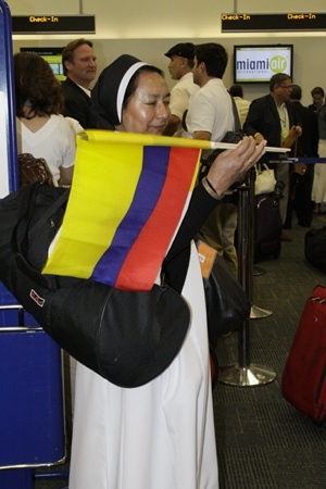 Sister Isabel Rincon, a Dominican sister who works at Gesu Church in Miami, shows off her native colors before boarding the flight to Santiago de Cuba.