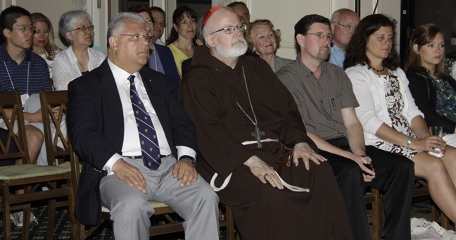 Boston Cardinal Sean O'Malley sits with fellow pilgrims during the reception at the home of John Caulfield, chief of the U.S. Interests Section in Havana.