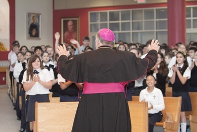 Archbishop Thomas Wenski tells the story of the three beans to sixth-graders gathered at St. Agatha Church for Focus 11.