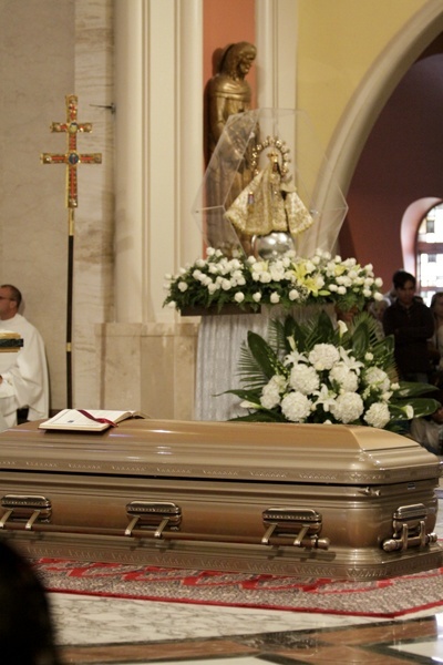 The pilgrim image of Our Lady of Charity watches over the body of Bishop Agustin Roman on the sanctuary of St. Mary Cathedral.