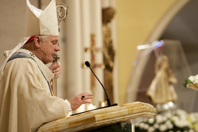 Framed by the image of Our Lady of Charity, Archbishop Thomas Wenski preaches the homily at the funeral Mass for Bishop Agustin Roman.