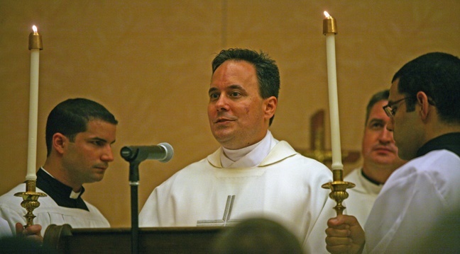 Father David Zirilli, director of the Propagation of the Faith for the Miami archdiocese, proclaims the Gospel.