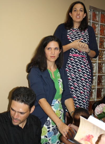 Co-authors Angelique Ruhi-Lopez, rear, and Carmen Santamaria speak at the book signing that followed the Mass. Santamaria's husband, Alejandro, is below in front.