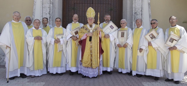 Archbishop Thomas Wenski poses for a picture after the Chrism Mass with the priests marking 25 and 50 years of ordination.