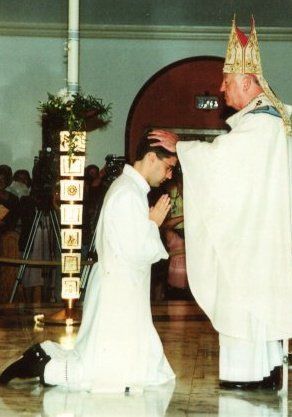 Archbishop John C. Favalora lays hands on Father Manny Alvarez, ordaining him a "priest forever."