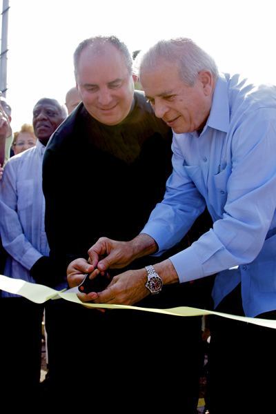 El Padre Juan Rumin Dominguez y el alcalde de la ciudad de Miami, Tomás Regalado, cortan la cinta de inauguración durante la ceremonia.