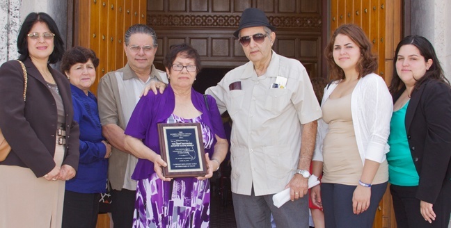 Members of Bishop Agustin Roman's family pose for a photograph after the Mass where the Lumen Christi award was given to them in his honor. From left: Ileana Martinez, Esperanza Martinez, Jorge L. Martinez, Iraida Martinez (holding the award), Jorge Luis Martinez, Angelica Martinez and Veronica Martinez.