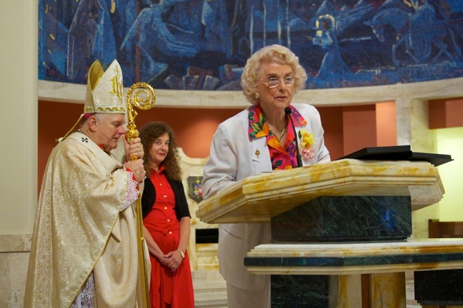 Marjorie P. Wessel, president of the Catholic Educators Guild, presents the Lumen Christi award to Bishop Agustin Roman's family as Archbishop Thomas Wenski and Kim Pryzbylski, archdiocesan superintendent of Schools, look on.