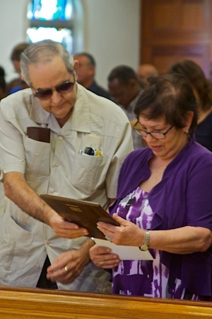 Bishop Agustin Roman's sister, Iraida Martinez, and her husband Jorge Luis Martinez look at the Lumen Christi award which they received posthumously on behalf of Bishop Roman.