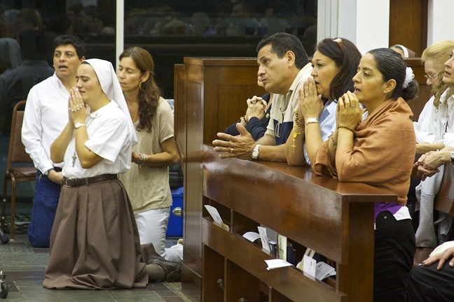 A Servant of the Pierced Hearts of Jesus and Mary prays with those in attendance during the consecration of the Eucharist.