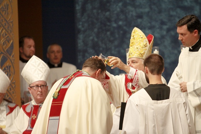 Archbishop Thomas Wenski consecrates Bishop Gregory Parkes by anointing him with the oil of chrism. At left is Bishop John Noonan of Orlando.