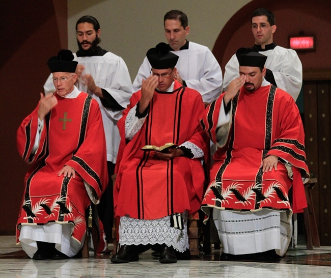 Father Chris Marino, center, Jesuit Father Christian Saenz, right, and Deacon Schaefer make the sign of the cross during the Mass.