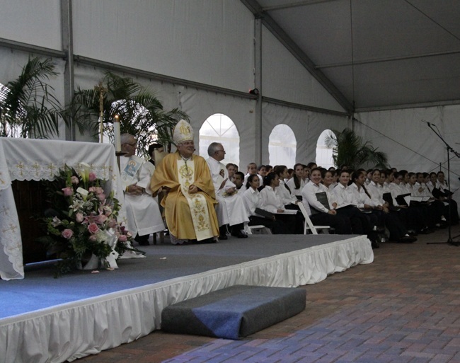 Archbishop Thomas Wenski looks on during a moment of the Mass on the feast of Our Lady of Mercy celebrated at Mercy Hospital Sept. 24. Behind him are members of the choir from Our Lady of Lourdes Academy in Miami, who led the singing during the Mass.