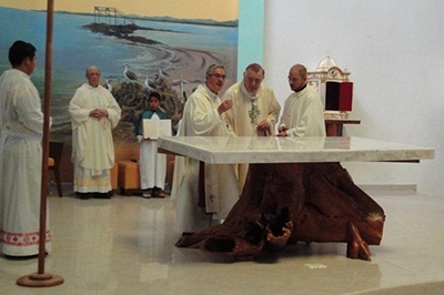 Archbishop Thomas Wenski and Bishop Manuel Valarezo place a relic in the altar of the Parroquia Cristo Salvador in the Galapagos.