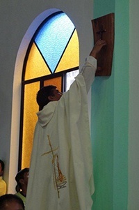 Father Angel Calderon, pastor of the Parroquia Cristo Salvador, anoints one of the Stations of the Cross in the newly-built church.