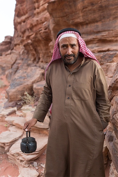 A Bedouin man serves afternoon tea in Jordans Wadi Rum, or Valley of the Moon, desert in southern Jordan, a location made famous for its connection with British officer T. E. Lawrence, who passed through several times during the Arab revolt of 1917-18. The village of Wadi Rum itself consists of several hundred Bedouin inhabitants with their goat-hair tents and concrete houses and also their four wheel vehicles.