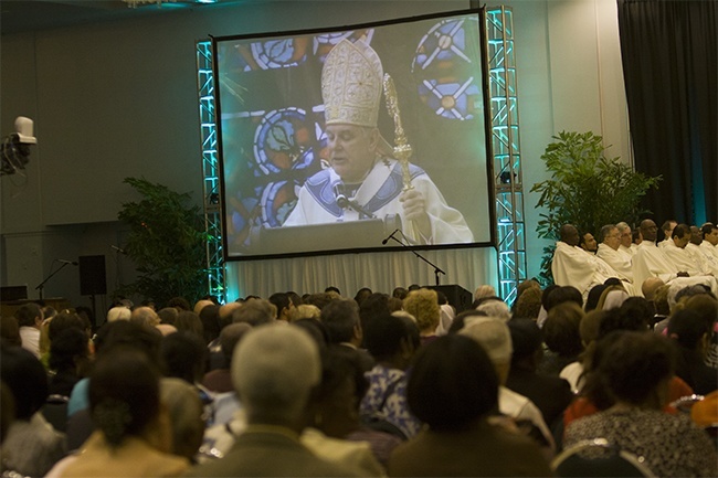 Archbishop Thomas Wenski's image is projected onto one of two large screens during the Synod closing Mass, which was broadcast live by EWTN and livestreamed on the websites of the Archdiocese of Miami and Radio Paz 830 AM.