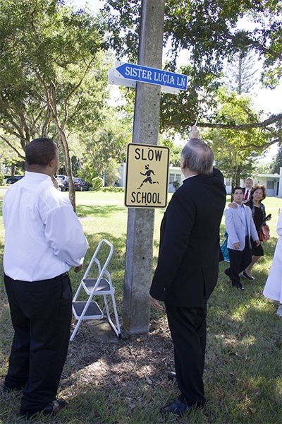 Archbishop Thomas Wenski blesses the street sign in honor of Sister Lucia Ceccotti, the Marian Center's founding executive director.