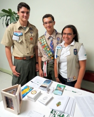 Nicolas Fernandez, Gabriel Seiglie and Isabelle Seiglie pose at the registration table where they spoke with attendees and handed out literature on Catholic Scouting.