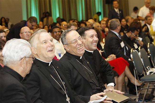 After speaking at the Synod closing assembly, Cardinal Oscar Rodriguez Maradiaga laughs at a joke made by co-master of ceremonies Father Jose Alvarez.