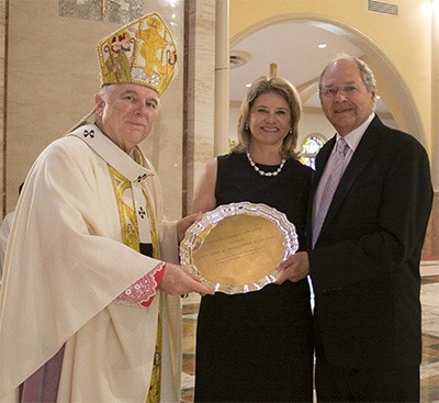 Archbishop Thomas Wenski gives the One in Hope award to Johanna and Stuart Harries of St. John Neumann Parish in Miami.