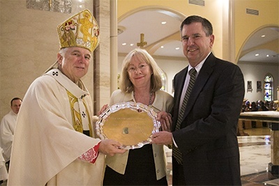 Archbishop Thomas Wenski gives the One in Charity award to Linda and Clay King of St. Coleman Parish in Pompano Beach.