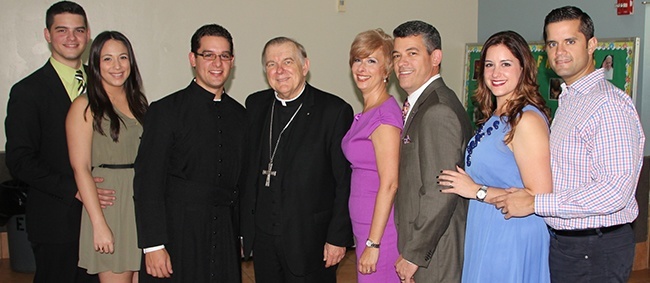 Members of the Garcia family pose for a photo with Archbishop Thomas Wenski after the Thanks4Giving Mass, from left: Steven Garcia, Elizabeth Gil, Bryan Garcia, Archbishop Wenski, Ana Garcia, Eddy Garcia, Jenise Subervi and Eddie Subervi.