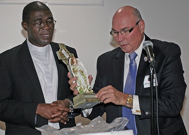 Raphael Lopez, Florida State Warden, Knights of Columbus gives Father Jude a statue of a guardian angel with its wings around a child.