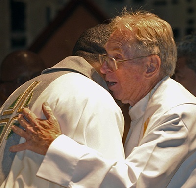 Father Michael "Happy" Hoyer hugs Father Jude Ezeanokwaza during the farewell Mass. Both worked together when Father Hoyer, now pastor of St. Gregory in Plantation, was pastor of Our Lady Queen of Martyrs in Fort Lauderdale.
