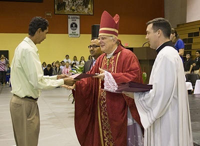 Braulio Herrera of Sacred Heart Church in Homestead receives his certificate acknowledging his status as a properly trained catechist from Archbishop Thomas Wenski.