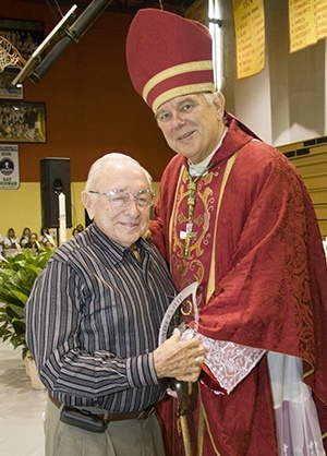 Archbishop Thomas Wenski presents Antonio Ginoris with a reminder of the catechetical award named in honor of his late wife, Esperanza Ginoris.