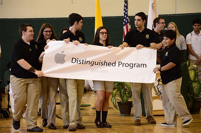 Immaculata-La Salle sophomores Brendon Cintas, Kathryn Sauer, Daniel Verdear and Amanda Alfaro, senior Ryan Rodriguez, and freshman Daniel Recinos, all members of the school's Tech Squad, proudly hold up the Apple Distinguished Program banner, presented to the school by Apple representatives Feb. 8.