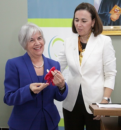 Claudia de la Cruz, president of The Centro Mater Foundation's board of directors, right, presents retiring executive director Miriam Roman with a medal of the Mater Admirabilis (admirable mother) for whom Centro Mater is named.