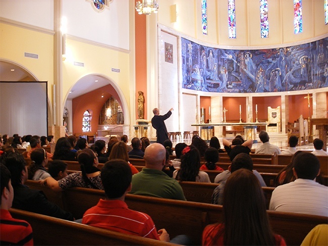 Father Christopher Marino, rector of St. Mary Cathedral, points out the mural that surrounds the sanctuary and explains its significance to parents, sponsors and those preparing to receive confirmation and first Communion this year.