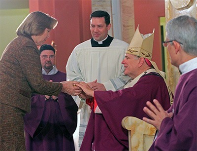 Archbishop Wenski receives the offertory gifts from Joan Crown, archdiocesan director of the respect life ministry.