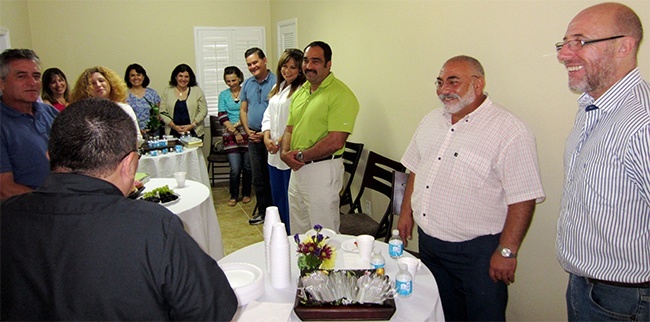 Deacon Edgardo Farias, facing away from the camera, introduces "God in the city" presenters Victor Hugo Russo and Ruben Aldo Linera.