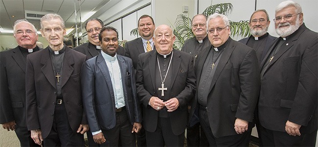 Oblate Missionaries pose with Archbishop Emeritus John C. Favalora after the farewell luncheon in their honor. From left: Father George Roy of St. Stephen Parish; Father Lucien Bouchard of Christ the King; Father Alejandro Roque of St. Stephen; Father Paul Dass of St. Stephen; Brother David Uribe, who is in formation and spending a pastoral year at St. Stephen; Archbishop Favalora; Father William Mason of Christ the King; Father John Cox of Holy Redeemer; Father James Taggart, councilor for the Northeast and Southeast areas of the province; and Father Daniel Nassaney, vocations director for the east coast.