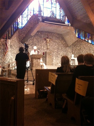 Archbishop Thomas Wenski preaches the homily as cameras stream the event live through the Web.