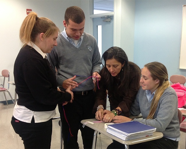 Any Rincon, third from left, teaches Archbishop Coleman Carroll campus ministers Karen Citron,  Jonathan Cruz and Alexis Cruz how to crate rope rosary bracelets.