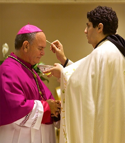 Father Ellie Saade, pastor of Our Lady of Lebanon, anoints Bishop Emeritus Fernando Isern of Pueblo, Colo., with holy oils brought from the tomb of St. Charbel in Lebanon.