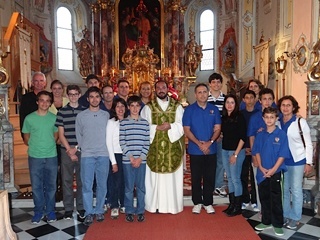 Jesuit Father Christian Saenz (’95) poses for a picture with members of the overseas study group after celebrating Mass at St. Thomas the Apostle Church in Tulfes, Austria.