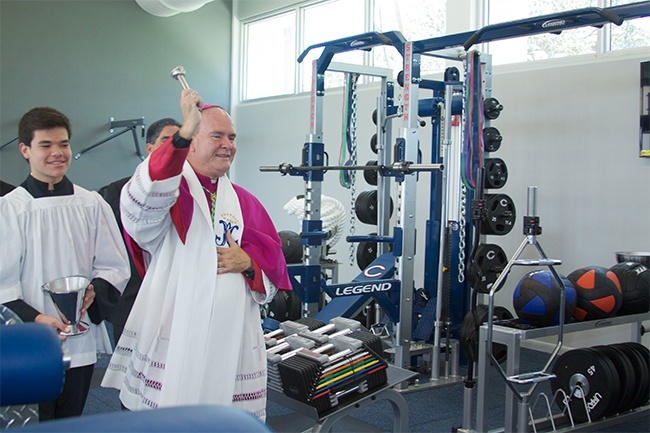 Bishop Fernando Isern, bishop emeritus of Pueblo, Colo., blesses with holy water the new All Sports Fitness Complex & Bernhardt Wellness Center at Christopher Columbus High School in Miami.