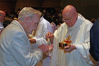 Msgr. James Fetscher, former St. Louis pastor, givis Communion to Gene Fleming, 91, a retired Pan-Am pilot and parishioner since 1979.