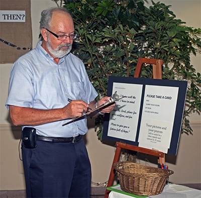 St. Louis parishioner Tom Van De Water writes a note for a time capsule that will be opened in 25 years.