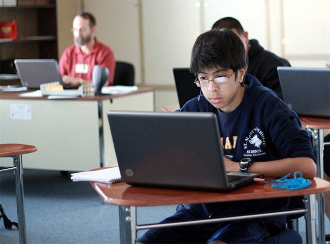 Carlos Dulcamara, 16, works on Virtual High School coursework from his school, St. Mary's Catholic School in Lawton, Okla.