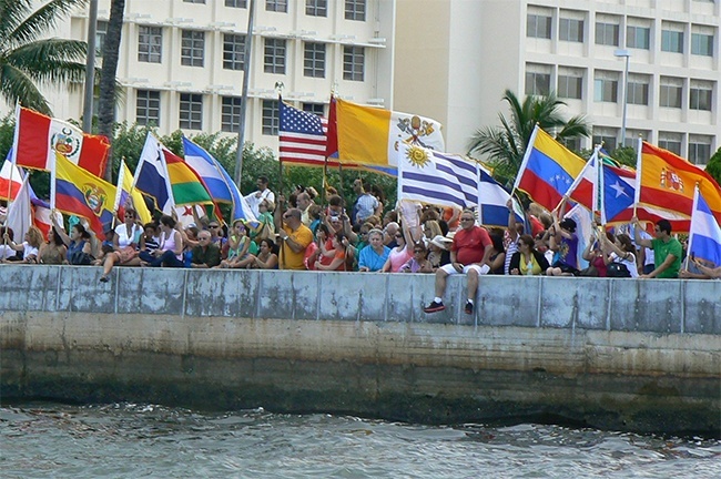 The faithful await the arrival of the image of Our Lady of Charity along the seawall at the Shrine.