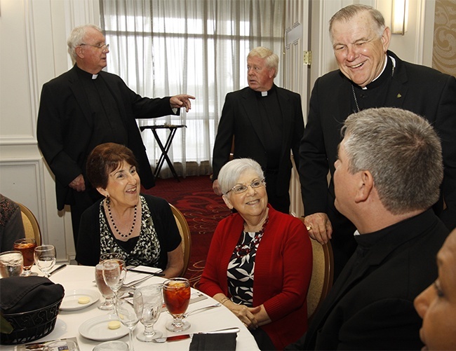 Archbishop Thomas Wenski greets Jackie Aguila, center, of St. Bartholomew Church in Miramar, and Father Jeff McCormick, pastor of St. Maximilian Kolbe Church in Pembroke Pines, as Mary Ann LoPiccola, left, looks on. Behind them are Msgr. Vincent Kelly, pastor of St. John the Baptist in Fort Lauderdale, and Father Edmond Prendergast, pastor of St. Bonaventure in Davie.